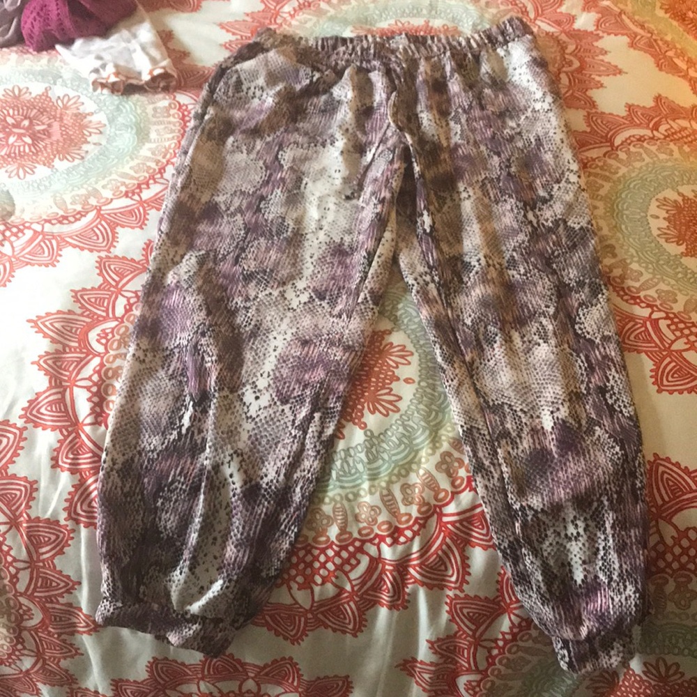 Snakeskin Jennifer Lopez ankle pants in purple and pink, cream and black.